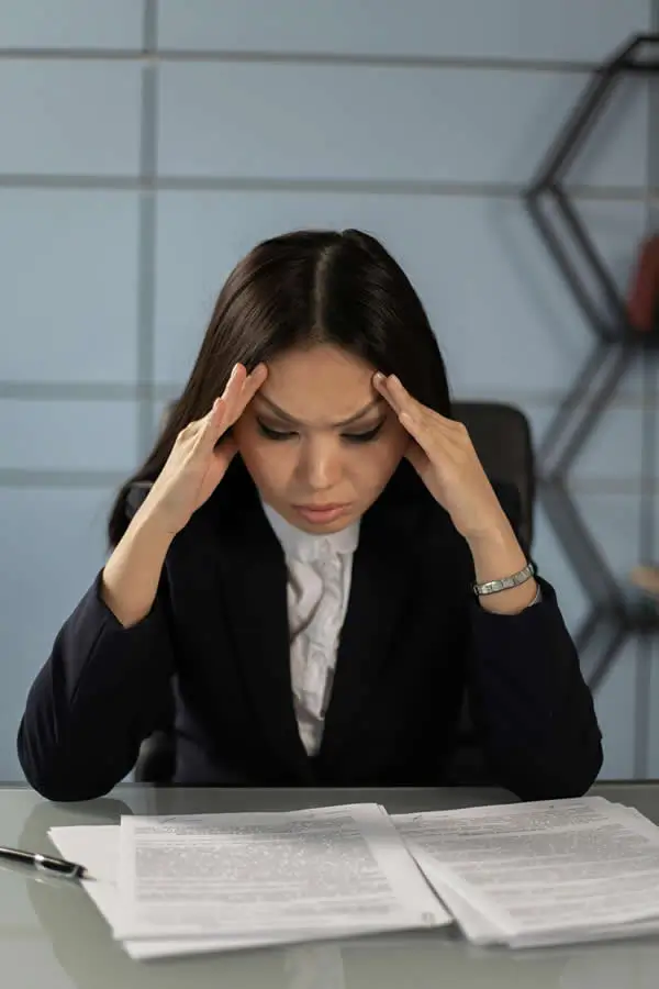 Professional woman experiencing migraine headache at work in Orlando office setting