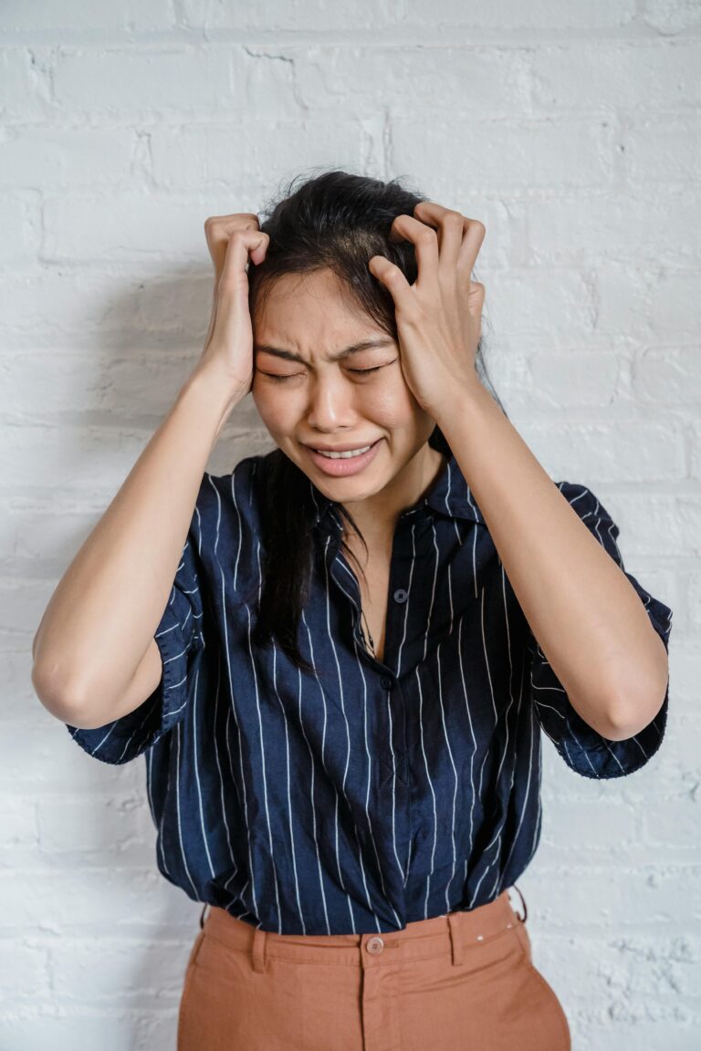 Woman experiencing chronic migraine pain holding her head